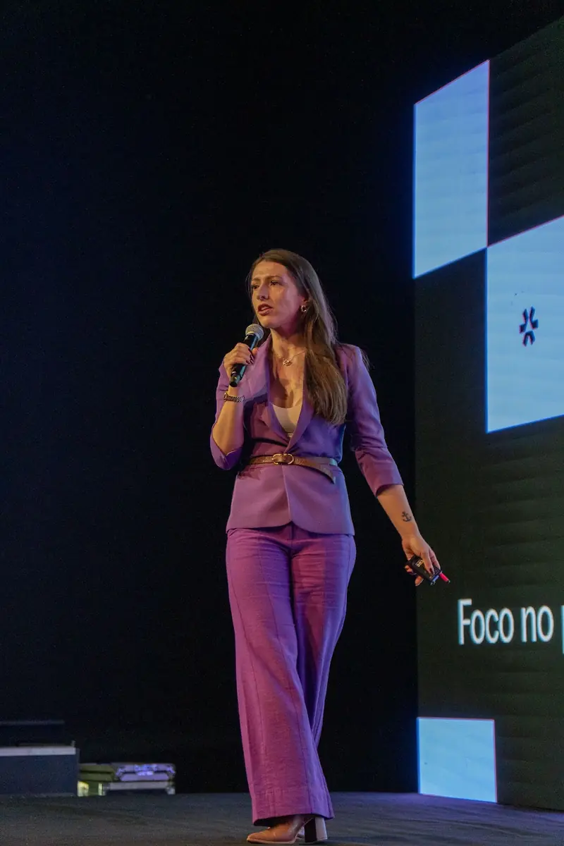 Bell caminhando no palco durante a apresentação presencial.